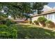 Well-maintained backyard with lush green grass, mature trees, and manicured landscaping at 240 Jumping Springs Pl, Henderson, NV 89012