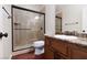 Bathroom featuring a stylish vanity, framed mirror, and tiled walk-in shower, providing a modern spa-like experience at 240 Jumping Springs Pl, Henderson, NV 89012