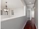 Bright hallway with hardwood floors and decorative chandelier, leading to bedrooms and other living spaces at 240 Jumping Springs Pl, Henderson, NV 89012