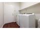 Laundry room with appliances, storage shelf and wood flooring offering both convenience and functionality at 240 Jumping Springs Pl, Henderson, NV 89012