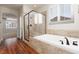 This main bathroom features a dual sink vanity, soaking tub, glass shower, and plantation shutters at 240 Jumping Springs Pl, Henderson, NV 89012