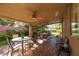 This covered patio features brick flooring, ceiling fans, and multiple seating areas for relaxation and entertainment at 240 Jumping Springs Pl, Henderson, NV 89012