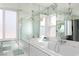 A bright bathroom with white marble tiles, mirrored walls, large windows and a spacious bathtub at 2712 Sidonia Ave, Las Vegas, NV 89102