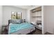 A well-lit bedroom has a large window, stylish decor, wood floors and a closet with built-in shelving at 2712 Sidonia Ave, Las Vegas, NV 89102