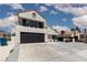 Two-story home featuring a black garage door, tiled roof, and desert landscaping at 2712 Sidonia Ave, Las Vegas, NV 89102