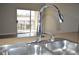Modern kitchen sink features a chrome faucet and a view to the outdoor balcony at 2900 Sunridge Heights Pkwy # 1733, Henderson, NV 89052