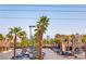 Commercial parking lot bordered by palm trees and retail buildings under a sunny sky at 3132 Centavo Dr, Las Vegas, NV 89117