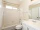 Bright bathroom featuring a shower-tub combo and a white tiled vanity with ample counter space at 3214 W Gilmore Ave, North Las Vegas, NV 89032