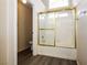 Bathroom with a shower-tub combo featuring white tile and gold trim at 3214 W Gilmore Ave, North Las Vegas, NV 89032