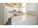 Well-lit kitchen boasting white cabinetry, light countertops, modern appliances, and hardwood floors at 3214 W Gilmore Ave, North Las Vegas, NV 89032