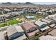An aerial view of a community with modern homes, a pool, playground, and picturesque mountain views on a clear day at 3216 Monte Luna Ave, Henderson, NV 89044