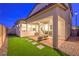 A cozy backyard featuring artificial grass, pavers and covered patio with dining set at 3216 Monte Luna Ave, Henderson, NV 89044