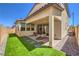 A cozy backyard featuring artificial grass, pavers and covered patio with dining set at 3216 Monte Luna Ave, Henderson, NV 89044