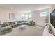 Bright, open living room with a large green corduroy sectional, big windows, and neutral carpeting at 3216 Monte Luna Ave, Henderson, NV 89044