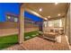 Comfortable covered patio featuring pavers, artificial turf, and privacy wall at dusk at 3216 Monte Luna Ave, Henderson, NV 89044