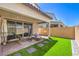 Picturesque covered patio with seating, pavers, artificial turf, and privacy wall at 3216 Monte Luna Ave, Henderson, NV 89044
