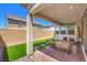 Covered patio featuring comfortable seating, pavers, and green turf at 3216 Monte Luna Ave, Henderson, NV 89044