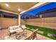 Relaxing covered patio with comfortable seating and artificial grass at dusk at 3216 Monte Luna Ave, Henderson, NV 89044