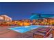 Night view of a luxurious community pool with ample seating and modern design at 3216 Monte Luna Ave, Henderson, NV 89044