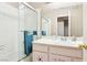 Bright bathroom with white tiled shower/bath, a mirror, and a vanity with a pink cabinet at 3233 Kinsale Ct, Las Vegas, NV 89121
