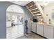 View of a laundry space with nearby stairs and access to the kitchen through an arched doorway at 3233 Kinsale Ct, Las Vegas, NV 89121