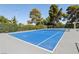 Bright blue community tennis court surrounded by a chain link fence and trees at 3233 Kinsale Ct, Las Vegas, NV 89121