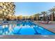 Outdoor pool with lounge chairs, palm trees, and building in the background on a clear, sunny day at 353 E Bonneville Ave # 632, Las Vegas, NV 89101