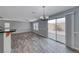 Dining area with wood-look floors, modern light fixtures, and sliding glass door to the backyard at 3696 Via Geneva, Henderson, NV 89052
