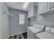 Functional laundry room with washer, dryer, storage cabinets, and shelving at 3696 Via Geneva, Henderson, NV 89052