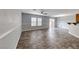 Open living room with wood-look flooring, modern ceiling fan, and lots of natural light from large windows at 3696 Via Geneva, Henderson, NV 89052