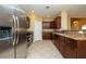 Open kitchen with stainless appliances, granite counters and dark wood cabinets at 5676 Bettors Luck Ct, Las Vegas, NV 89122