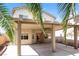 Covered patio of two-story home with palm trees on a sunny day at 5676 Bettors Luck Ct, Las Vegas, NV 89122
