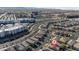 An elevated view shows a community of modern homes with palm tree-lined streets, and city views in the distance at 6848 Calvitero St, Las Vegas, NV 89149