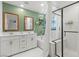 Bright bathroom with white vanity, double sinks, tub and a separate glass-enclosed shower at 6848 Calvitero St, Las Vegas, NV 89149