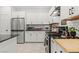 A well-equipped kitchen with stainless steel appliances, white cabinetry, and black countertops with modern subway tile backsplash at 6848 Calvitero St, Las Vegas, NV 89149