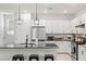 Modern kitchen featuring white cabinets, stainless steel appliances, and a sleek black countertop island with barstool seating at 6848 Calvitero St, Las Vegas, NV 89149