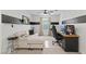 Cozy living room with a sectional sofa, desk, and computer setup, featuring a modern black and white color scheme at 6848 Calvitero St, Las Vegas, NV 89149