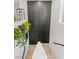 Carpeted stairs with white walls, a black accent wall, and decorative plants, creating a welcoming and modern entryway at 6848 Calvitero St, Las Vegas, NV 89149