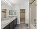Modern bathroom featuring double sinks, granite countertops, sleek cabinetry, and a shower-tub combo at 6850 Magenta Moon St, North Las Vegas, NV 89086