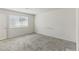 Empty bedroom with neutral carpet, white walls, and a large window for natural light at 6850 Magenta Moon St, North Las Vegas, NV 89086