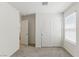 Bedroom with plush carpet, white sliding closet doors, and natural light at 6850 Magenta Moon St, North Las Vegas, NV 89086