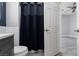 Bathroom featuring tiled shower with dark curtain, white cabinets, and gray floors at 689 Principle Point Ave, Henderson, NV 89012