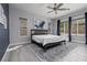 Bright bedroom featuring a ceiling fan, large windows, and stylish accent wall at 689 Principle Point Ave, Henderson, NV 89012