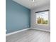Cozy bedroom with blue accent wall, window, and gray flooring, offering a peaceful retreat at 689 Principle Point Ave, Henderson, NV 89012