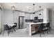Eat-in kitchen features stainless appliances, breakfast bar with chairs, and modern pendant lighting at 689 Principle Point Ave, Henderson, NV 89012