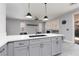 Modern kitchen island with gray cabinets, white countertop, and pendant lighting at 689 Principle Point Ave, Henderson, NV 89012
