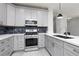 Updated kitchen includes gray cabinetry, stainless appliances, light countertops and black backsplash at 689 Principle Point Ave, Henderson, NV 89012