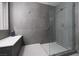 Contemporary walk-in shower featuring gray tiling, glass enclosure, and a built-in bench at 689 Principle Point Ave, Henderson, NV 89012
