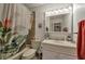 Neutral bathroom featuring tub with floral curtain, marble vanity, and medicine cabinet with decorative lighting at 7055 Sylvan Oak Dr, Las Vegas, NV 89147