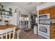 Bright kitchen with wooden cabinets, white appliances, and a sliding glass door providing access to the backyard at 7055 Sylvan Oak Dr, Las Vegas, NV 89147